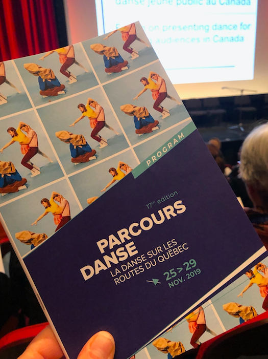 Parcours Danse program held up in front of stage