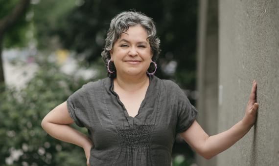 Michelle Olson poses outside leaning against a wall