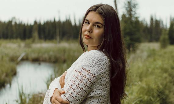 Sara Kae with her arms crossed standing in marshlands