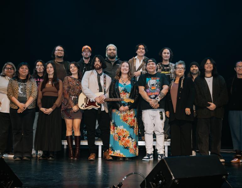 Participants of the Soundin Rez programs (young artists) lined up in a group on stage for a photo.