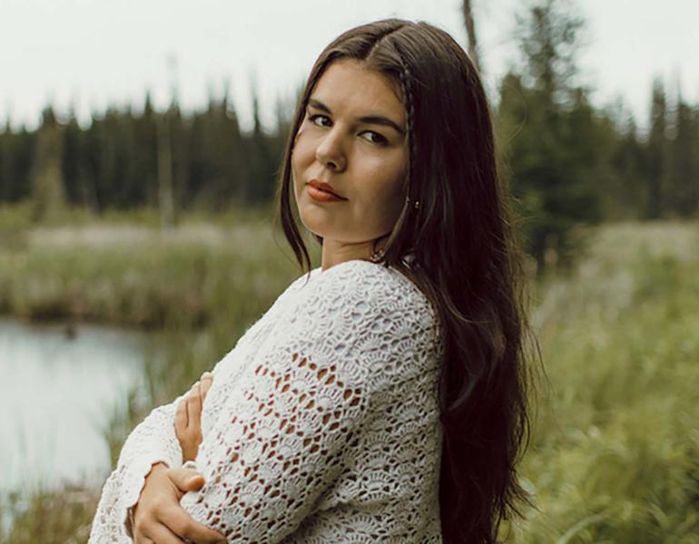 Sara Kae with her arms crossed standing in marshlands