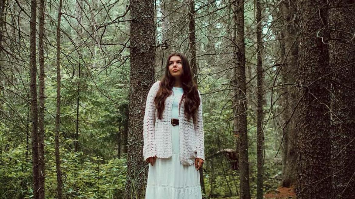 Sara Kae standing in the forest.